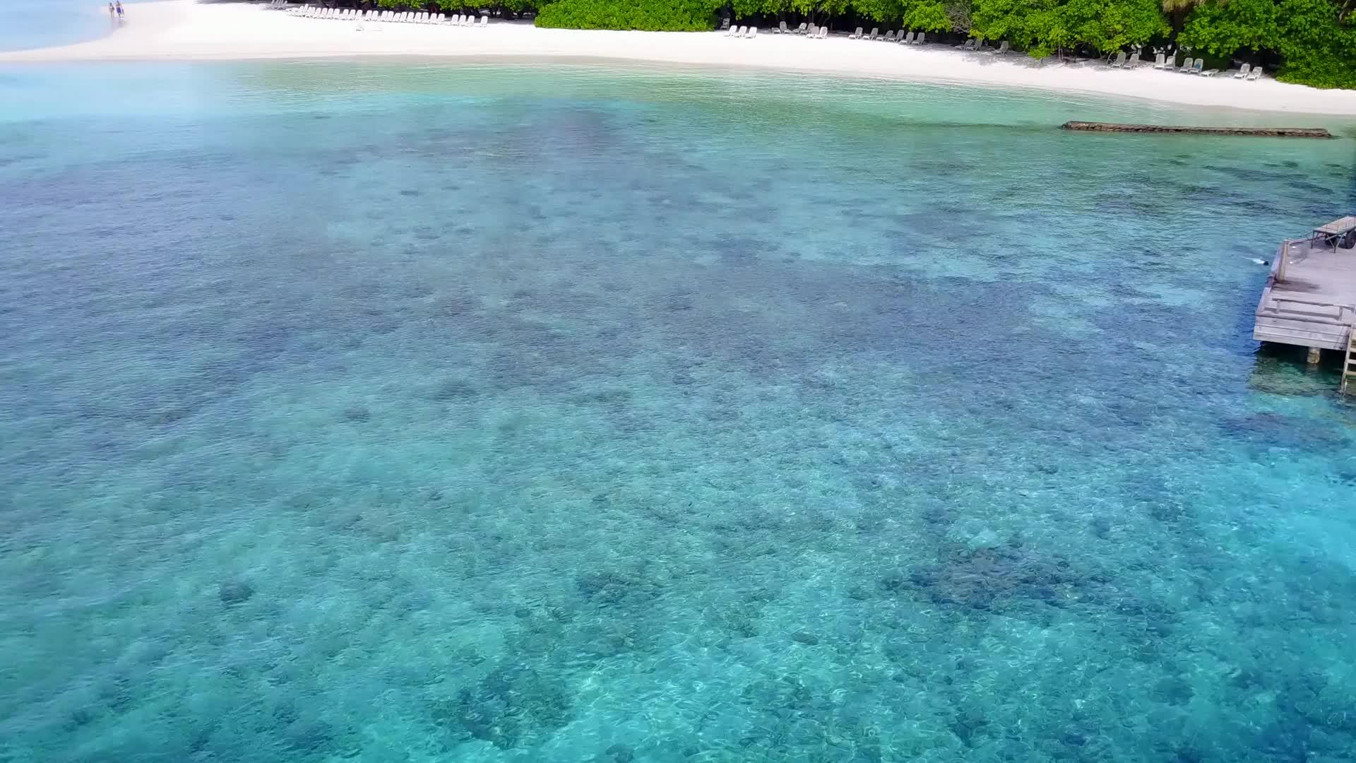 以黄昏前的蓝水礁湖和浅沙为例靠近热带海滩视频的预览图
