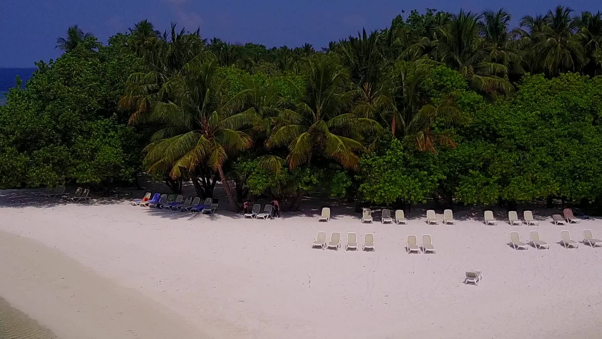 在清澈的环礁湖和阳光下的白色沙滩背景下在宁静的海滩上视频的预览图
