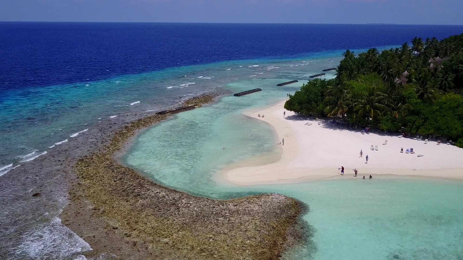 白沙背景穿过完美的海岸海滩靠近棕榈的透明海洋视频的预览图