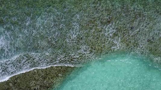 海浪附近有一个白色的海滩背景绿松石环礁湖海滨度假日视频的预览图
