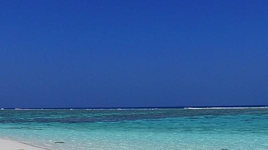 在蓝滩附近的蓝色海洋和白色沙滩背景下阳光明媚海岸安静视频的预览图