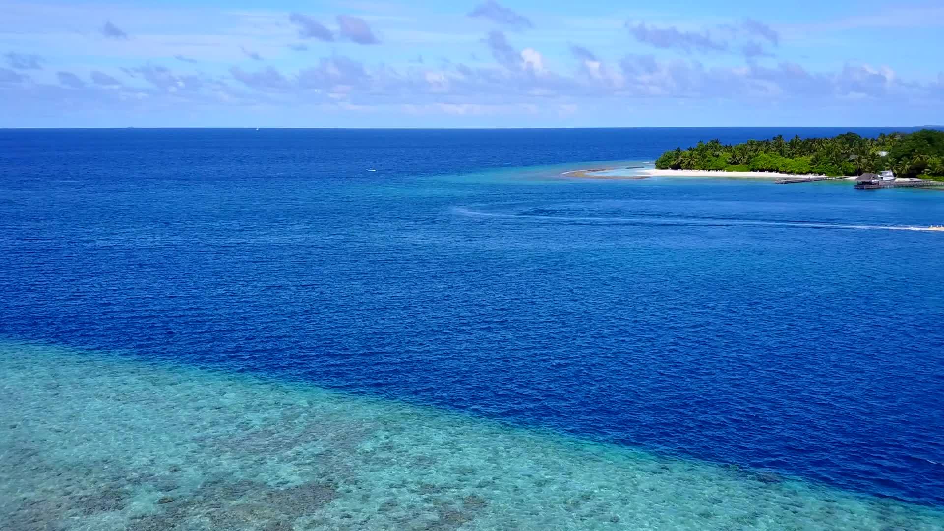 蓝色环礁湖和白色色环礁湖和白色沙滩背景下的晴天热带风景视频的预览图