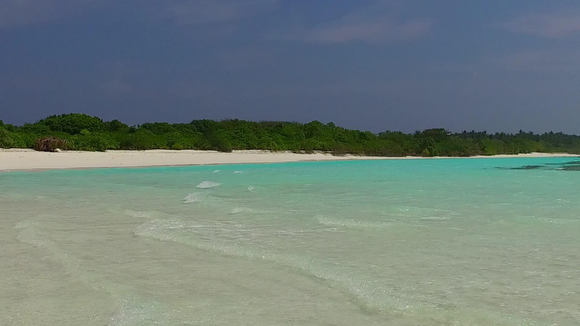 蓝色泻湖和珊瑚礁附近的白色海滩背景视频的预览图