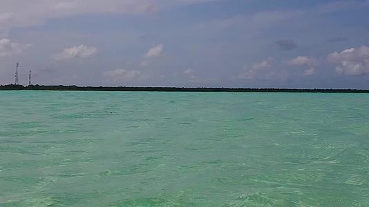 蓝色环礁湖位于棕榈树附近有白沙背景在海边旅行时放松海岸线视频的预览图