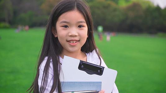 抱着书和文件夹的小女生视频的预览图