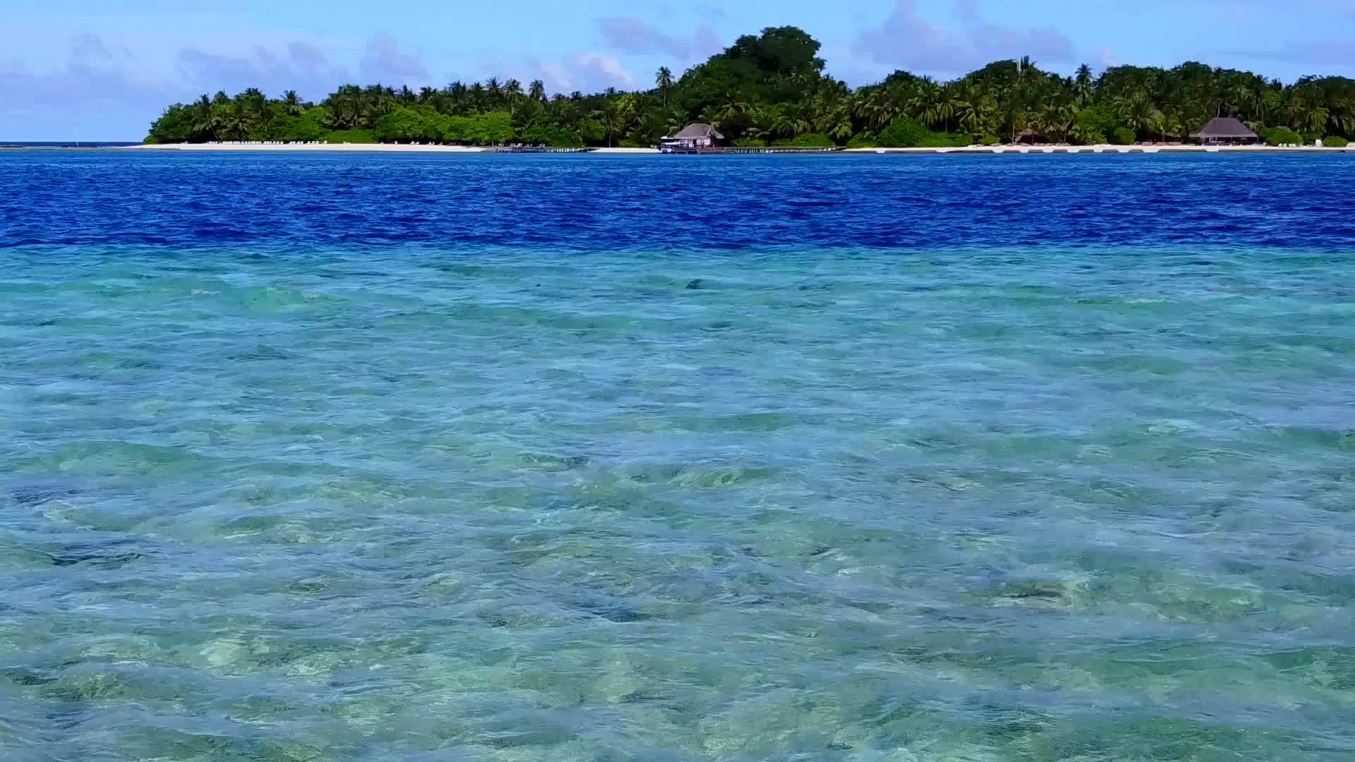 蓝浪附近的蓝水和白沙背景特写了豪华度假村海滩时间的纹理视频的预览图