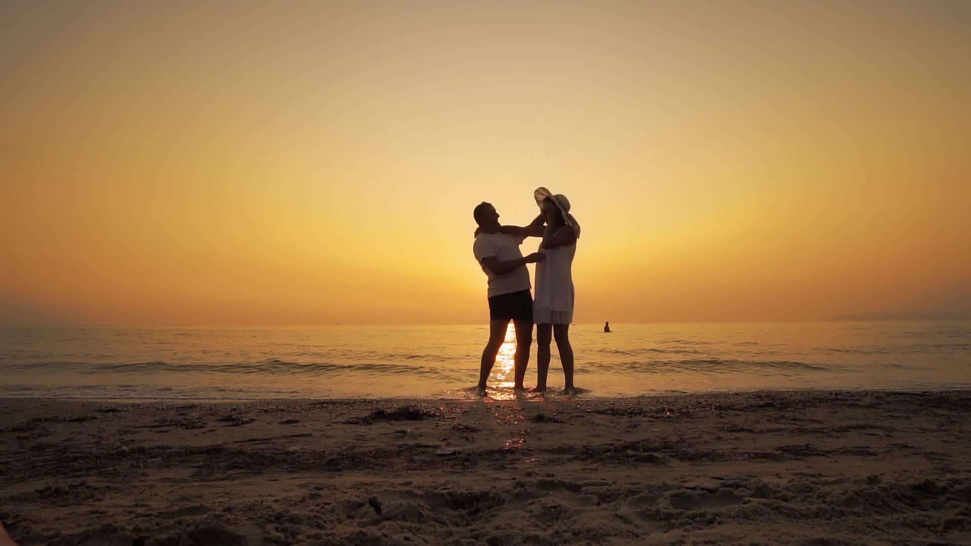 情侣们在海滩日落时交换感情握手微笑慢动作视频的预览图