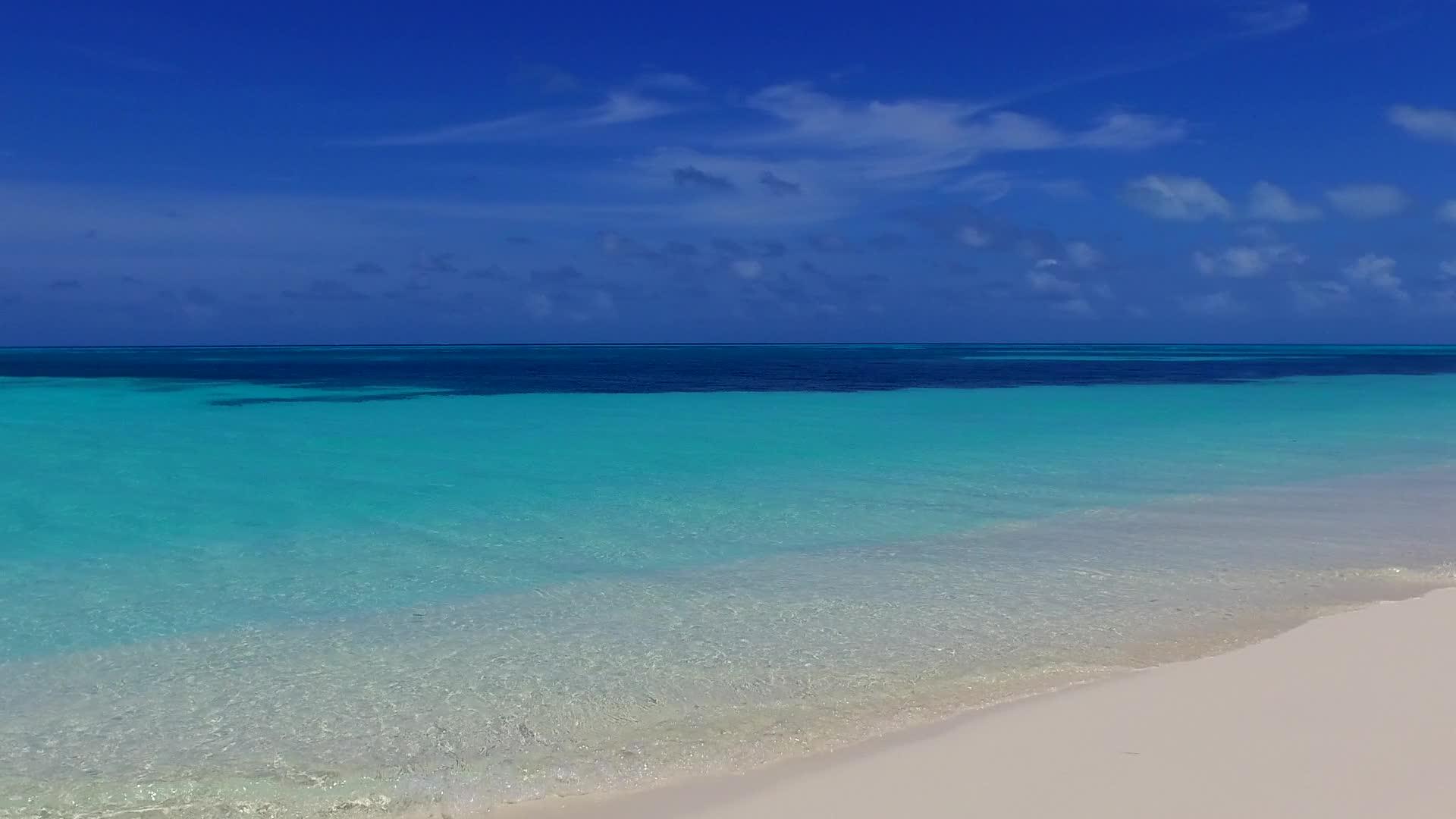 海浪附近安静的海岸线使用蓝色海洋和白色沙尘背景视频的预览图