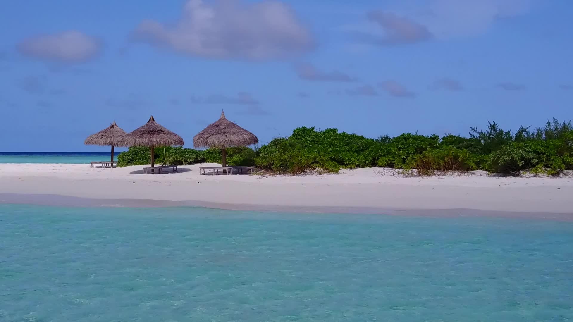 阳光明媚的寒冷海洋旅行通过水蓝色的水和阳光下的白色沙滩背景视频的预览图