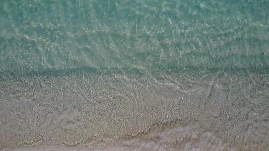 阳光明媚的蓝色海滩生活方式在珊瑚礁附近有一个白色的海滩背景视频的预览图