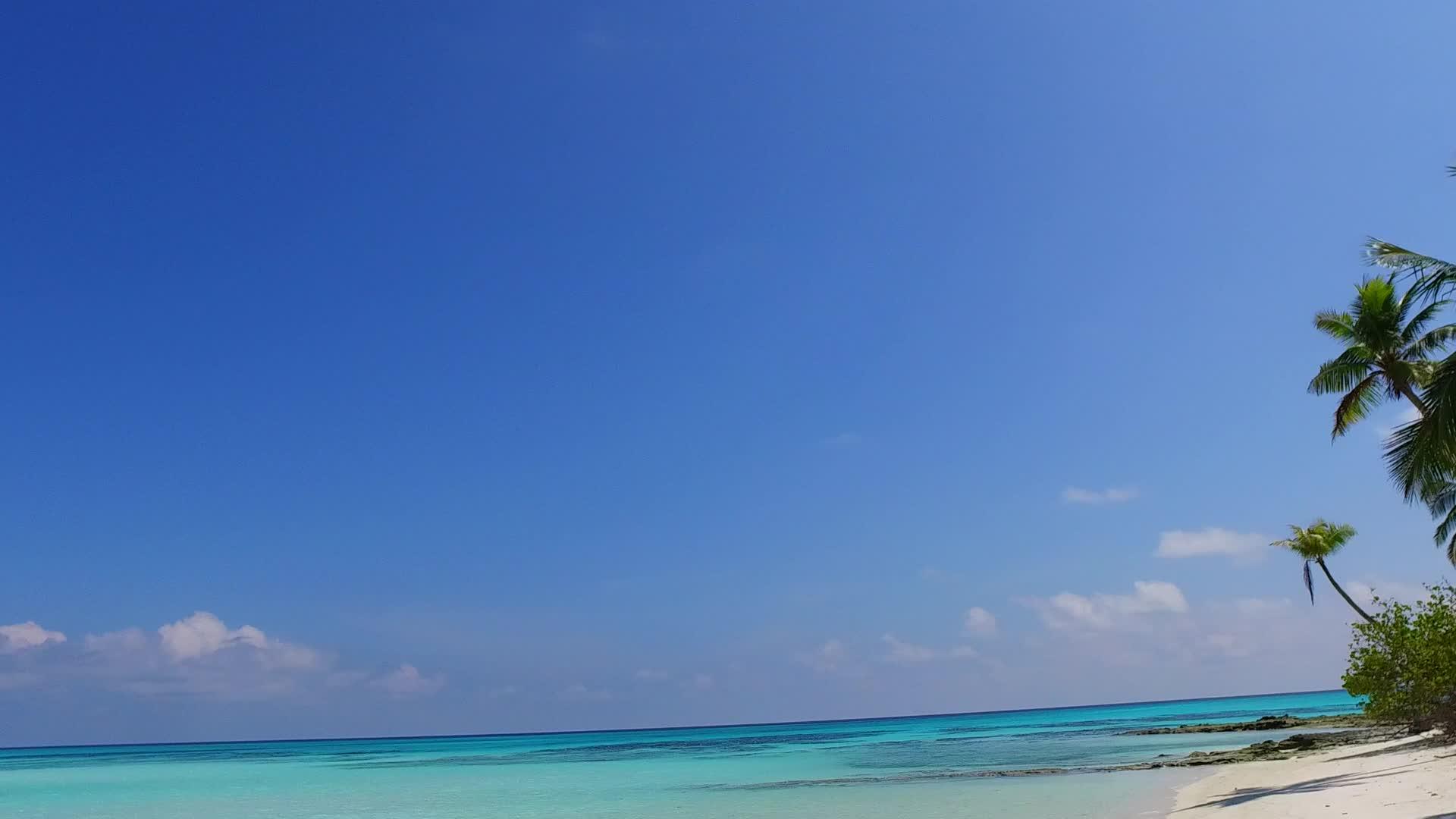 海浪附近完美的旅游海滩蓝色海底和白色沙底背景视频的预览图