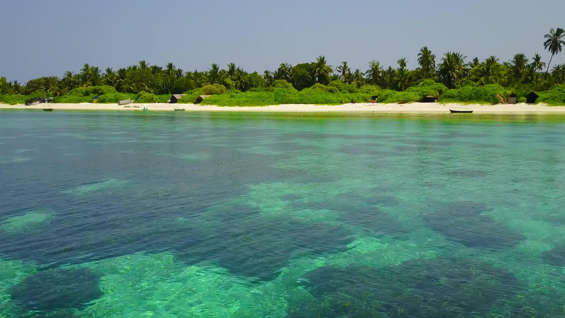 清澈的大海和冲浪附近的白色海滩有着完美的背景视频的预览图