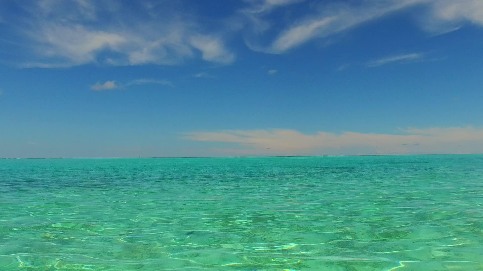 阳光明媚的豪华海滩之旅通过蓝色海洋穿过其白色沙滩背景视频的预览图