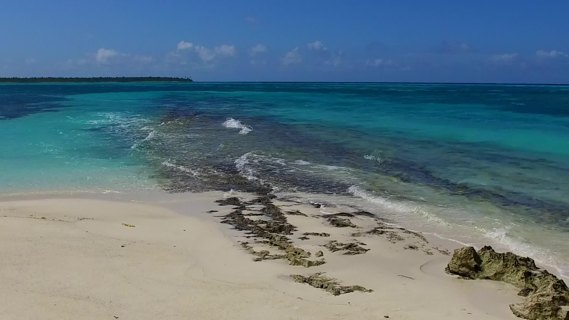 白色沙质背景下的蓝绿色泻湖热带海滩之旅阳光下的空旷之旅视频的预览图