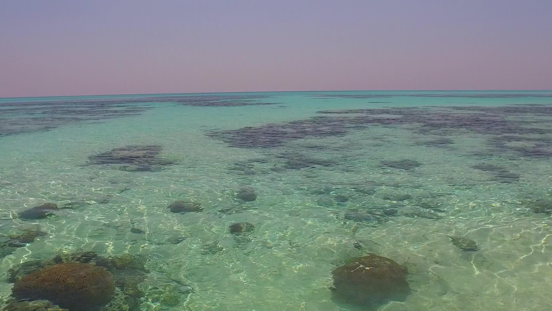 沙巴附近的蓝绿色海洋有一个白色沙滩背景的白色沙滩夜晚视频的预览图