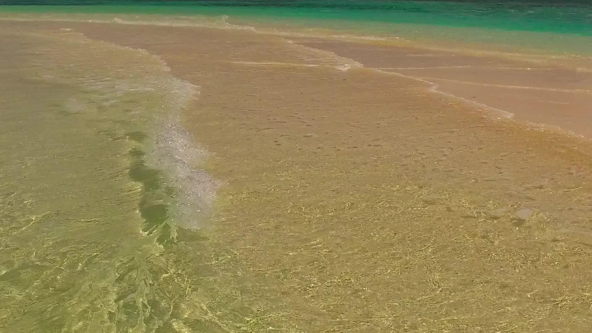 浅环礁湖和阳光下白色沙滩背景的裸露度假胜地视频的预览图