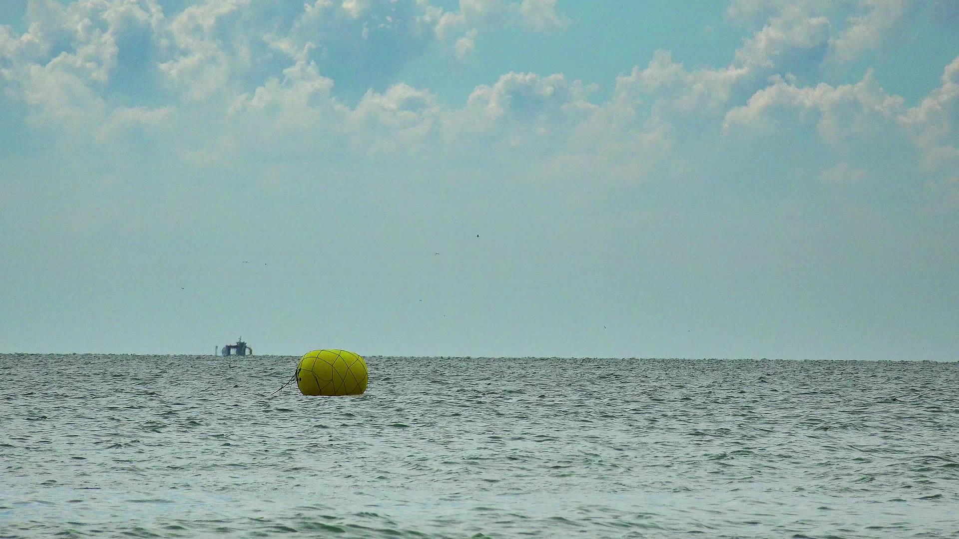 大型球际浮标漂浮在海平线波上视频的预览图