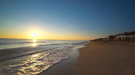 海浪在日落和日出的背景下喷洒夏季海滩视频的预览图