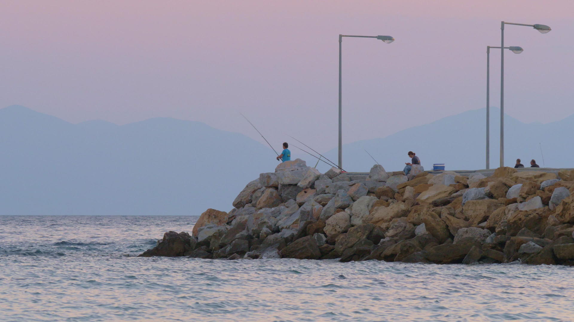 人们在海上码头钓鱼晚上放松风景甜点视频的预览图