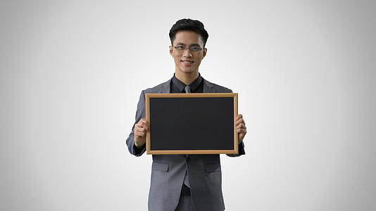 4k灰幕戴眼镜的商务男性展示黑板形象视频的预览图