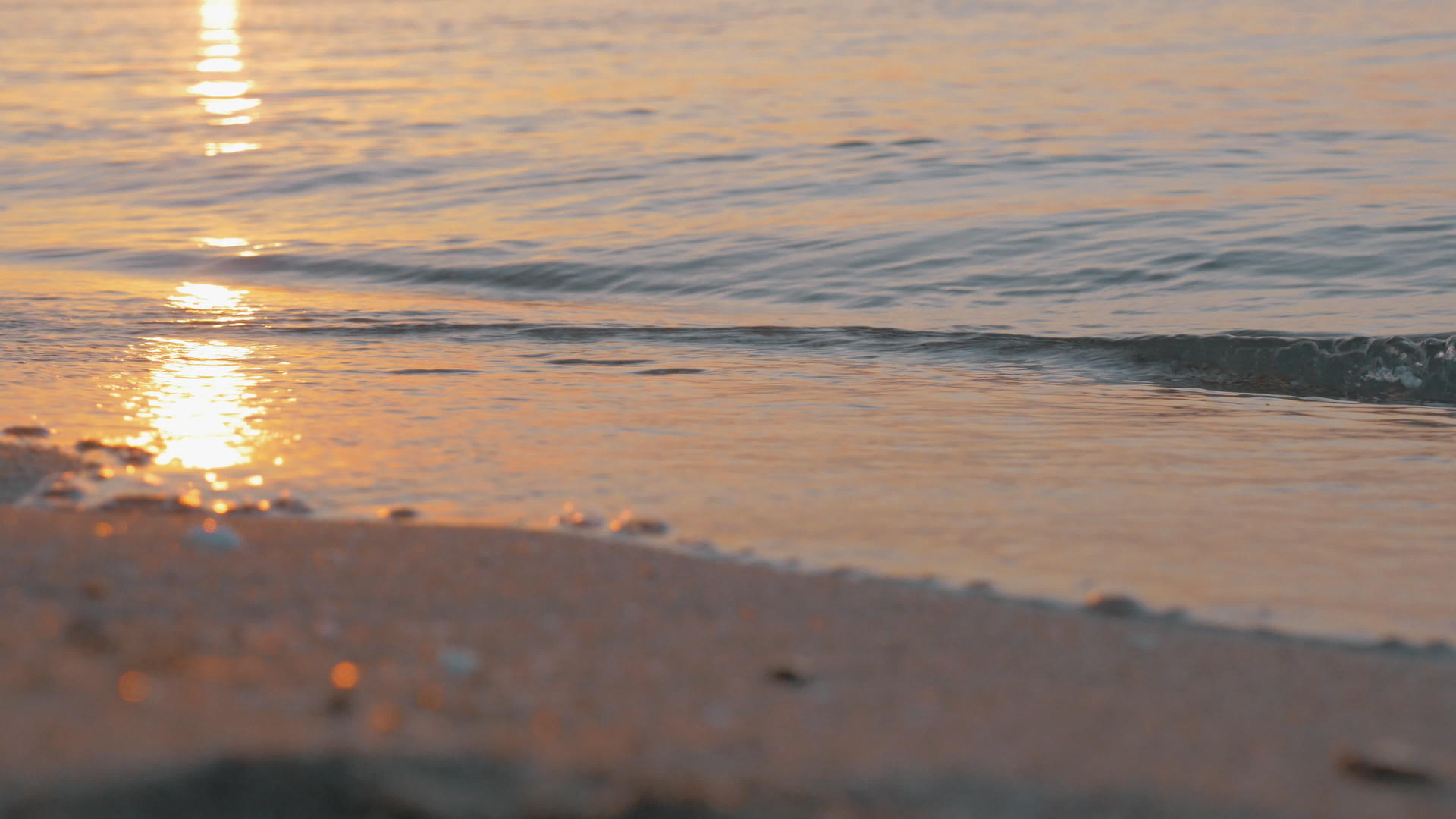 海浪在日落时向海岸滚动视频的预览图