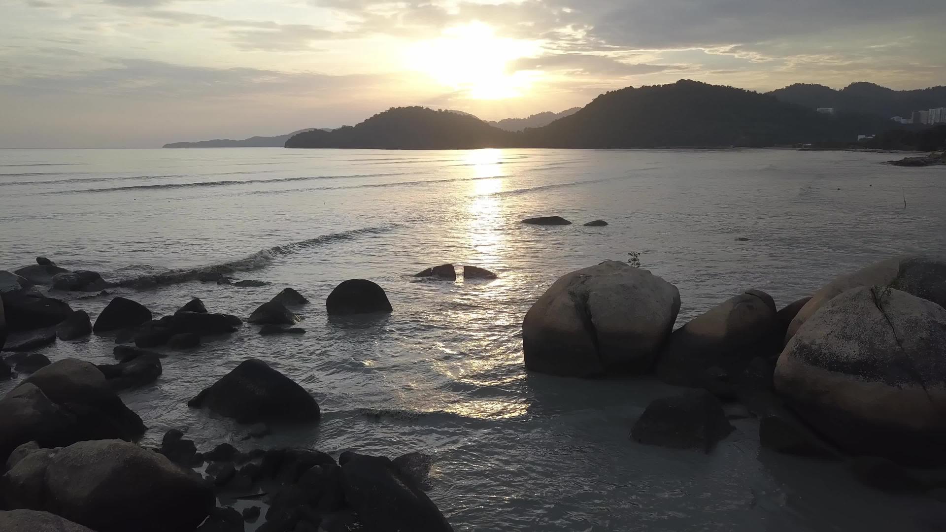日落时有岩石和海洋视频的预览图