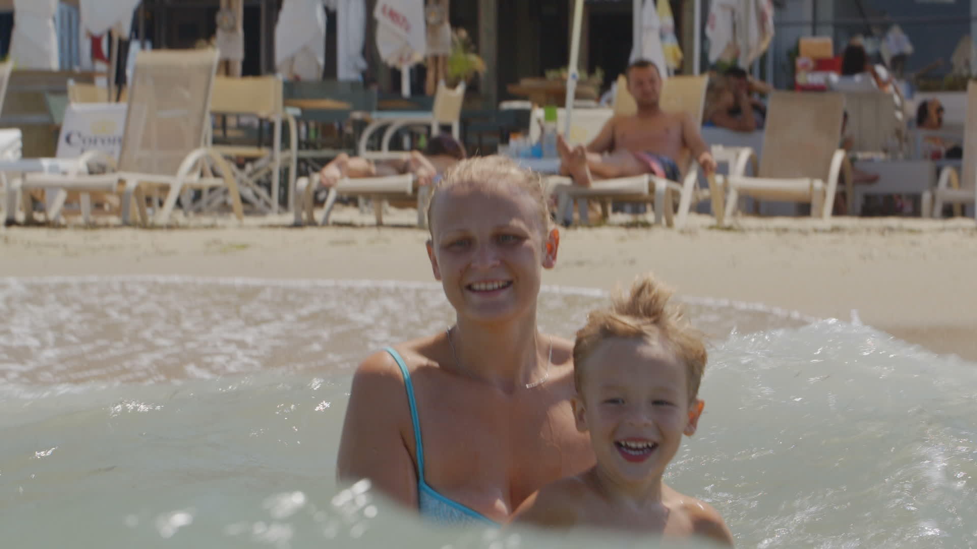 母亲和儿子在海浪中跳跃视频的预览图