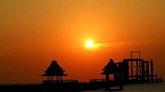 日落过橙色的云和两片月光海两个废弃的亭子视频的预览图