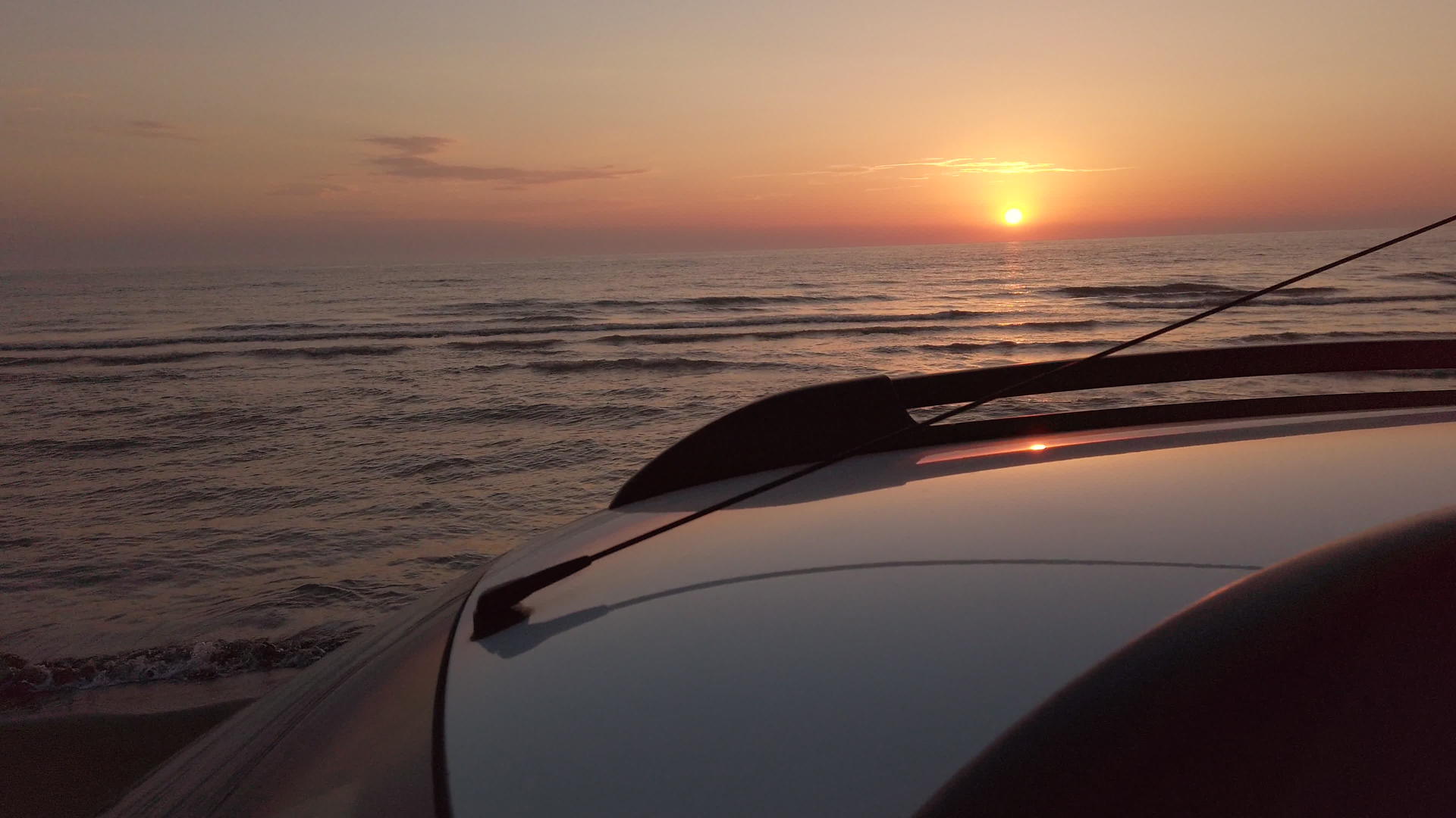 日落时在海滩上开车SUV在沙滩上开车视频的预览图