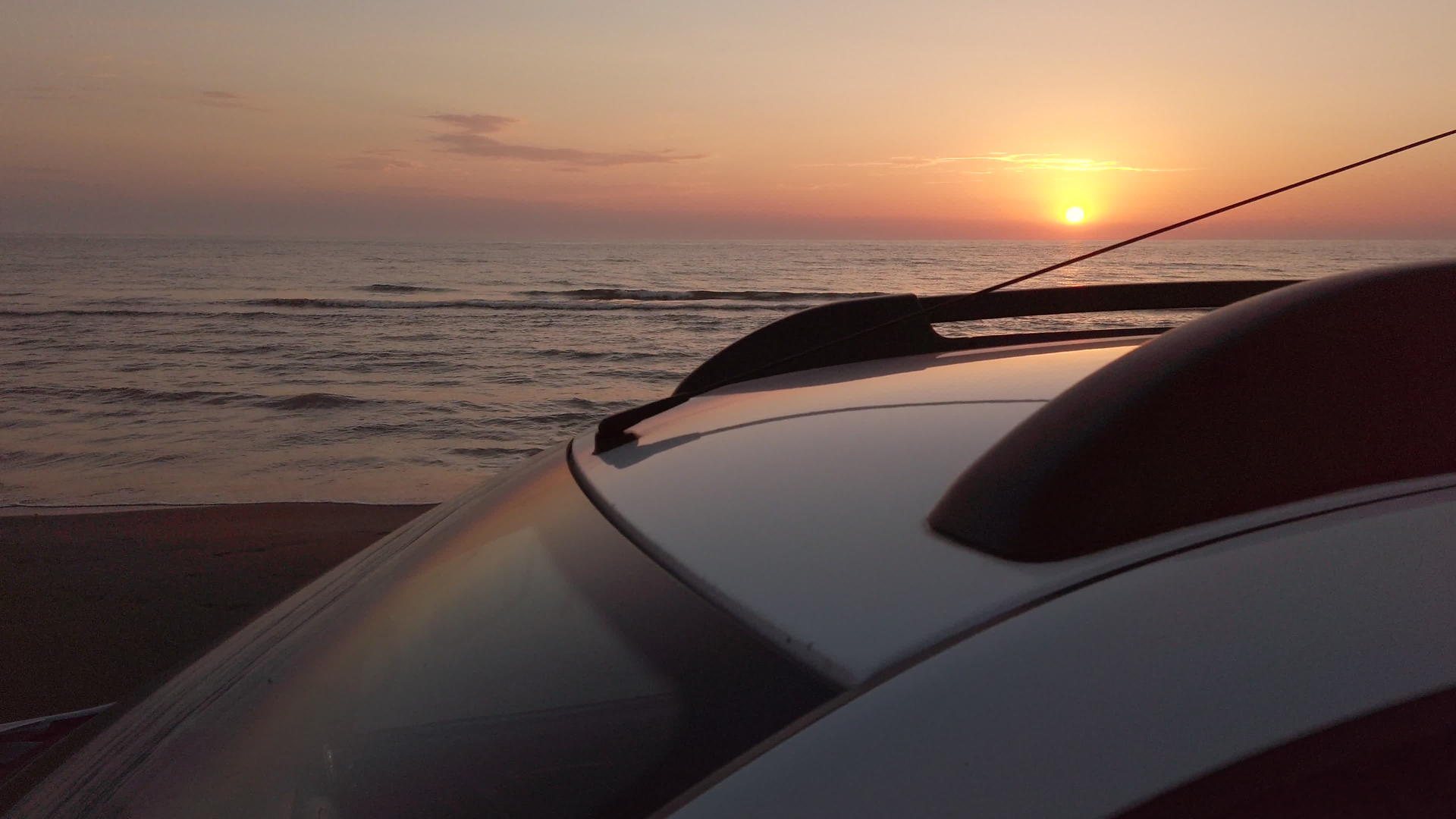 日落时在海滩上开车SUV在沙滩上开车视频的预览图