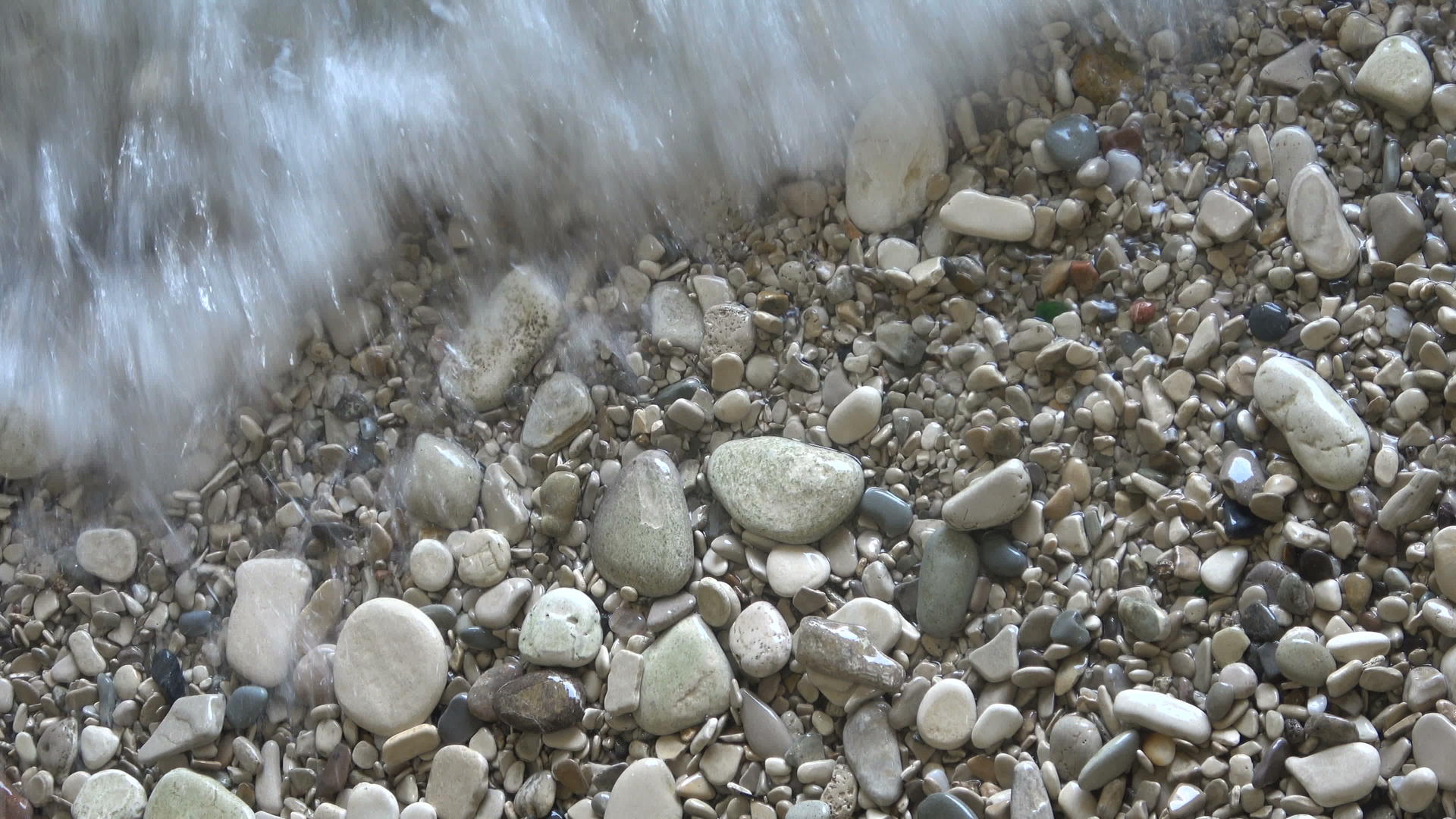 石头上的卵石上的海水视频的预览图