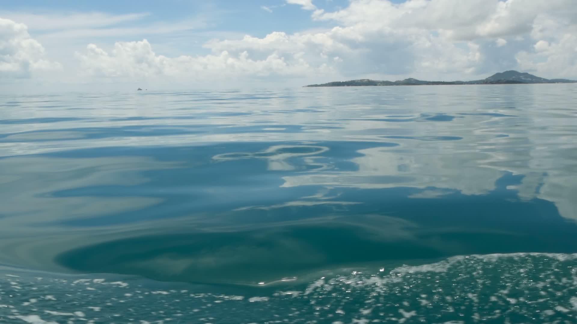 在阴天的小船和平静的海洋之后的小泡沫蓝色波浪田园诗视频的预览图