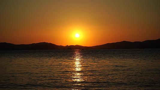 美丽的橙色海边日落在深山的海面上视频的预览图