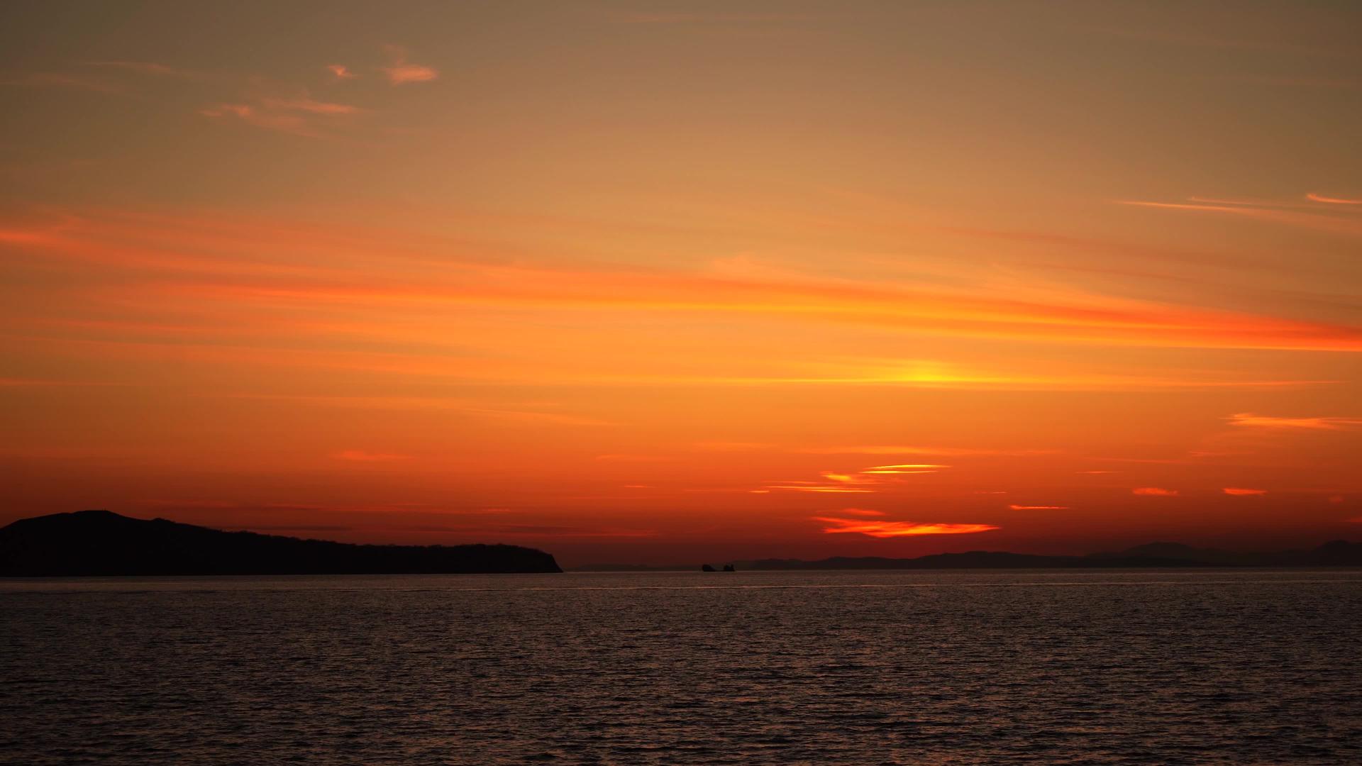 美丽的橙色海边日落在深山的海面上视频的预览图