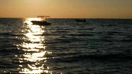 4K在日落或日出时背景小船在海上的剪影视频的预览图
