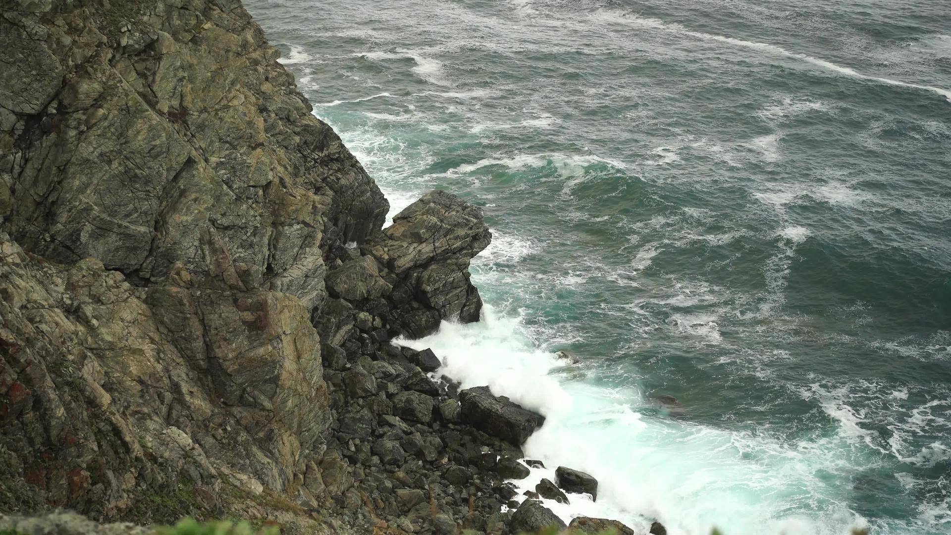 看看岩石上破碎的波浪的高度视频的预览图
