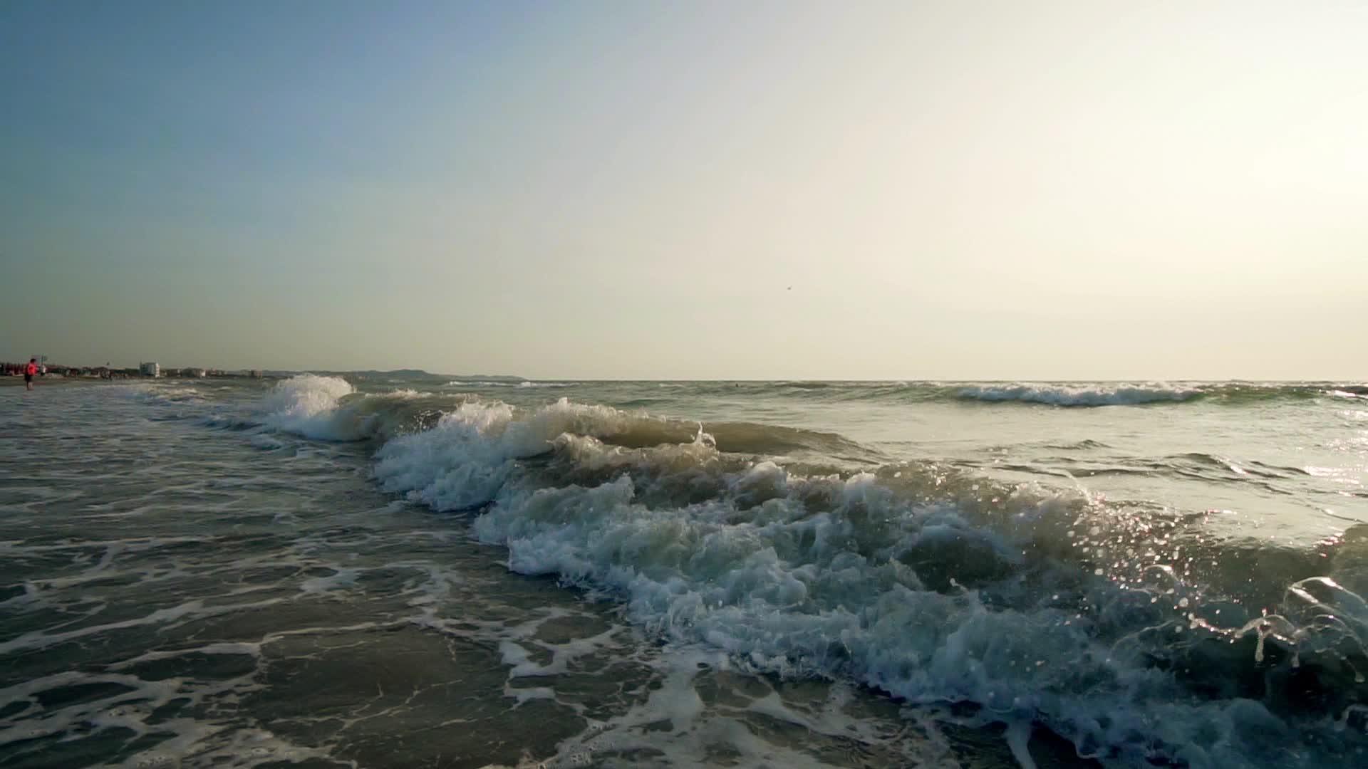 海滩上缓慢移动的海浪在海上喷洒泡沫视频的预览图