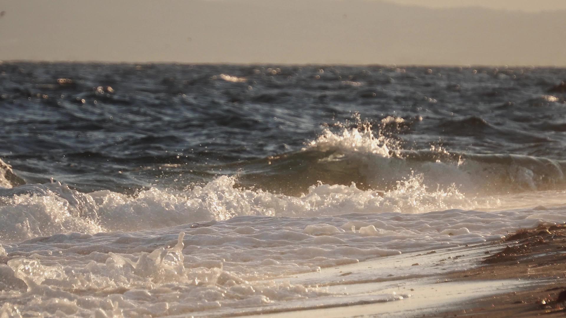 海浪在春天的雷雨中喷洒沙滩沙子视频的预览图