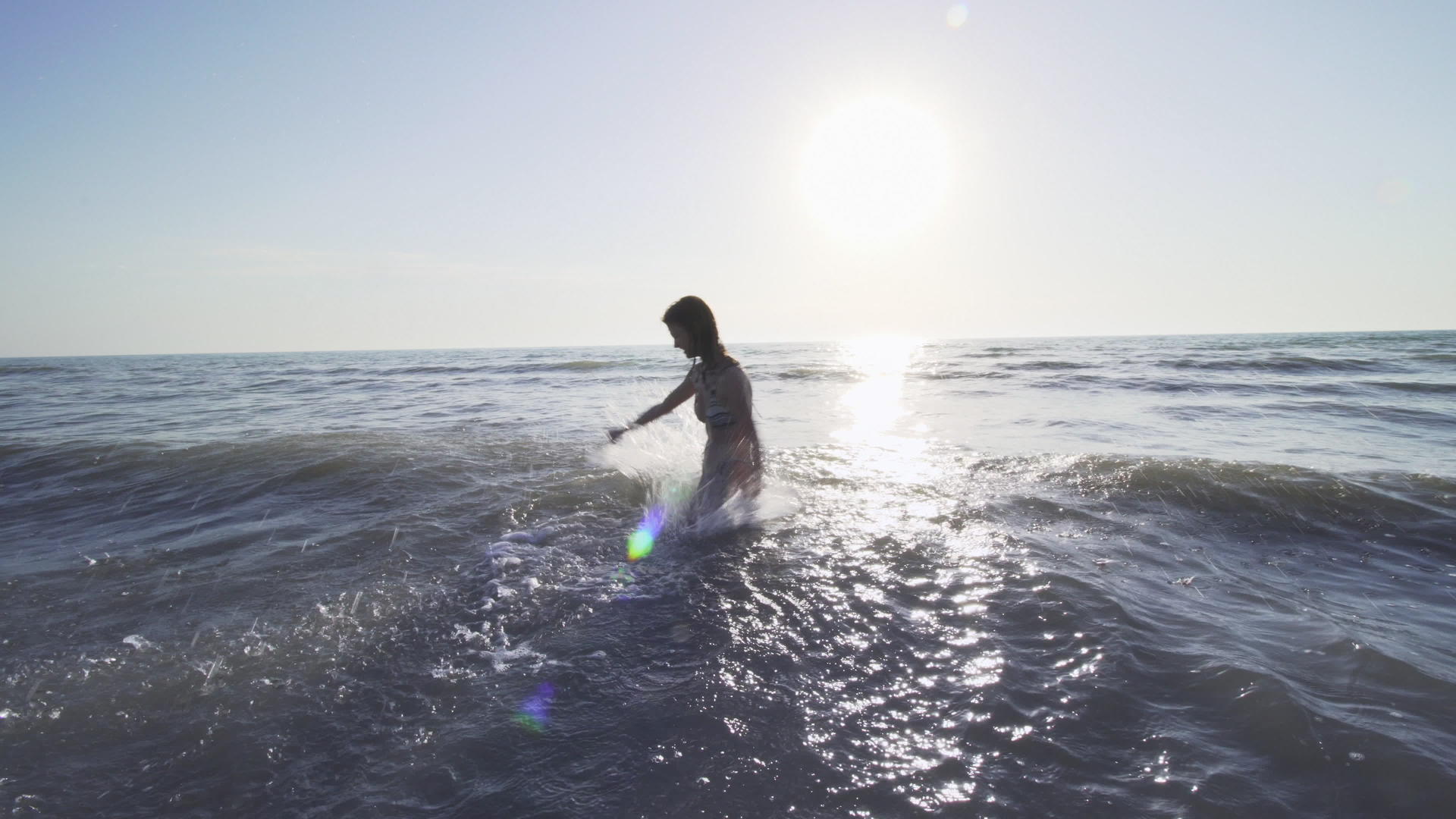 日落时穿着比基尼的女孩在海里喷水视频的预览图