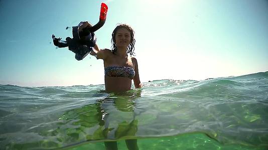 暑假概念快乐的女孩戴着面具在海里跳跃和微笑gopro视频的预览图