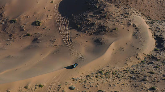 航拍腾格里沙漠中奔驰的越野车4k视频视频的预览图