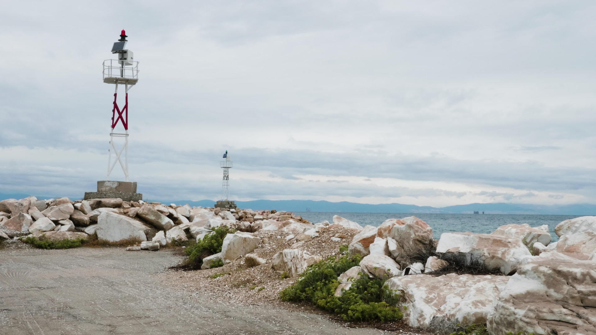 在岩石海滩和平静的海水上建造小灯塔视频的预览图