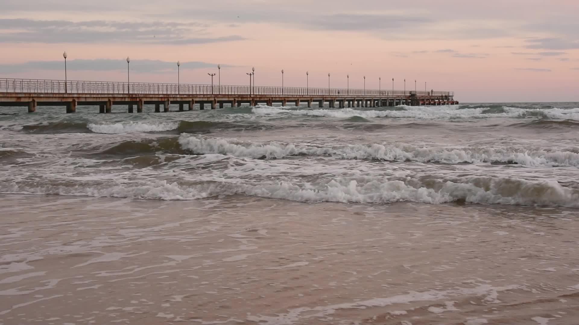 海军码头延伸到远处海浪在岸边滚动视频的预览图