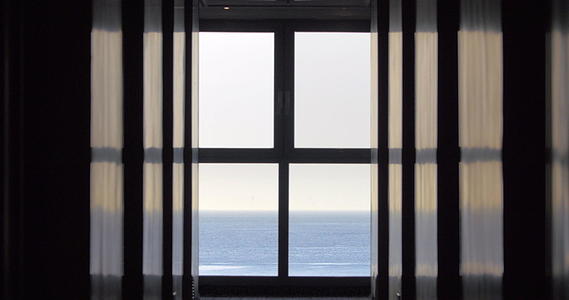 从房子或酒店的窗口望去蓝色的无尽海洋视频的预览图
