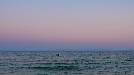 夜晚水景和孤独的船在海浪中摇曳视频的预览图