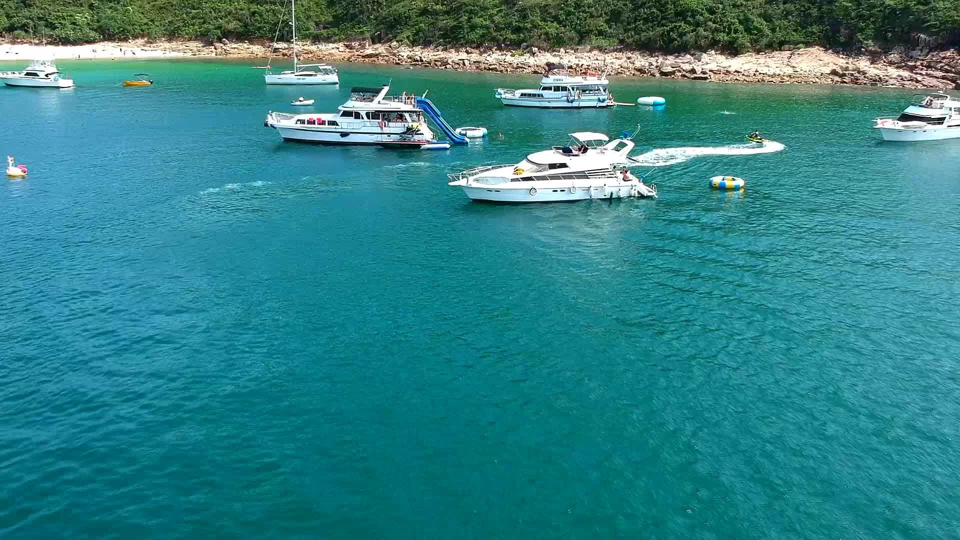 游艇和游泳者在海湾附近的无人驾驶场景视频的预览图