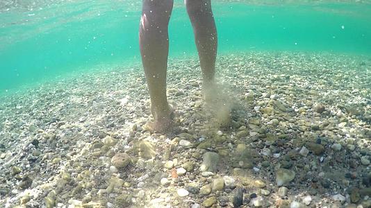 用小石头在海底漂浮的水下脚视频的预览图