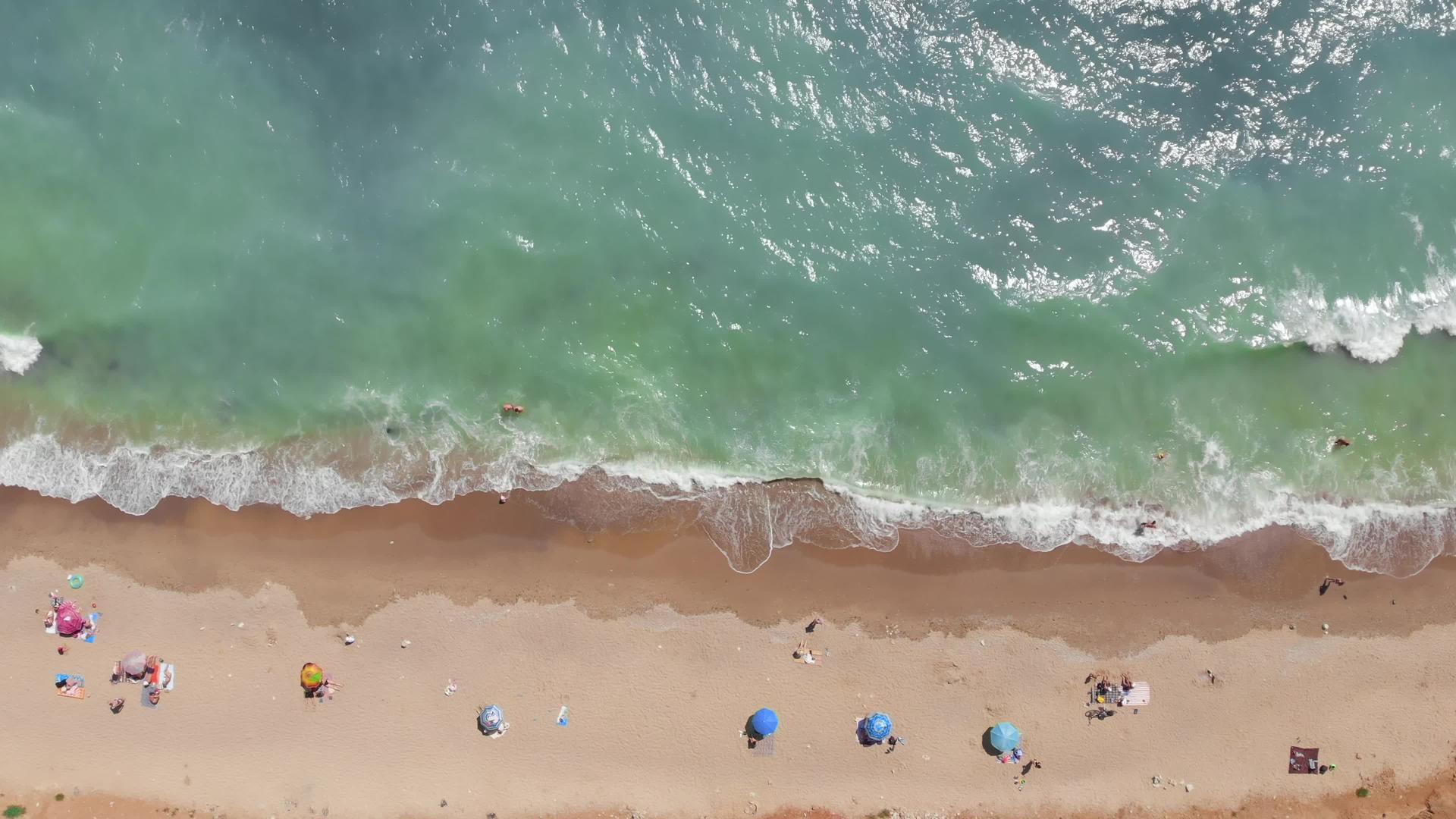 黑海美丽的野生海滩顶部空中角度人们沐浴在阳光下游泳视频的预览图