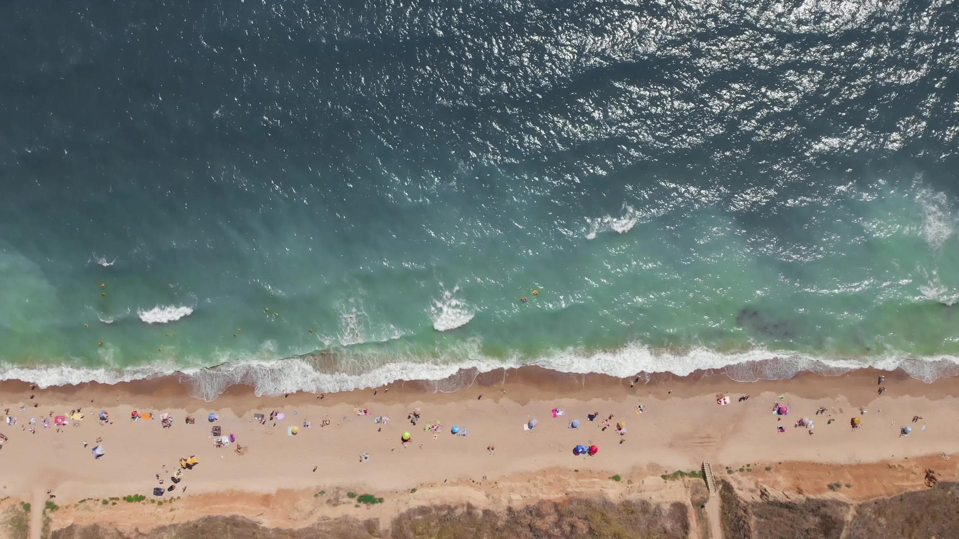 高角度的空气人们沐浴在阳光下游泳在海边玩得开心视频的预览图