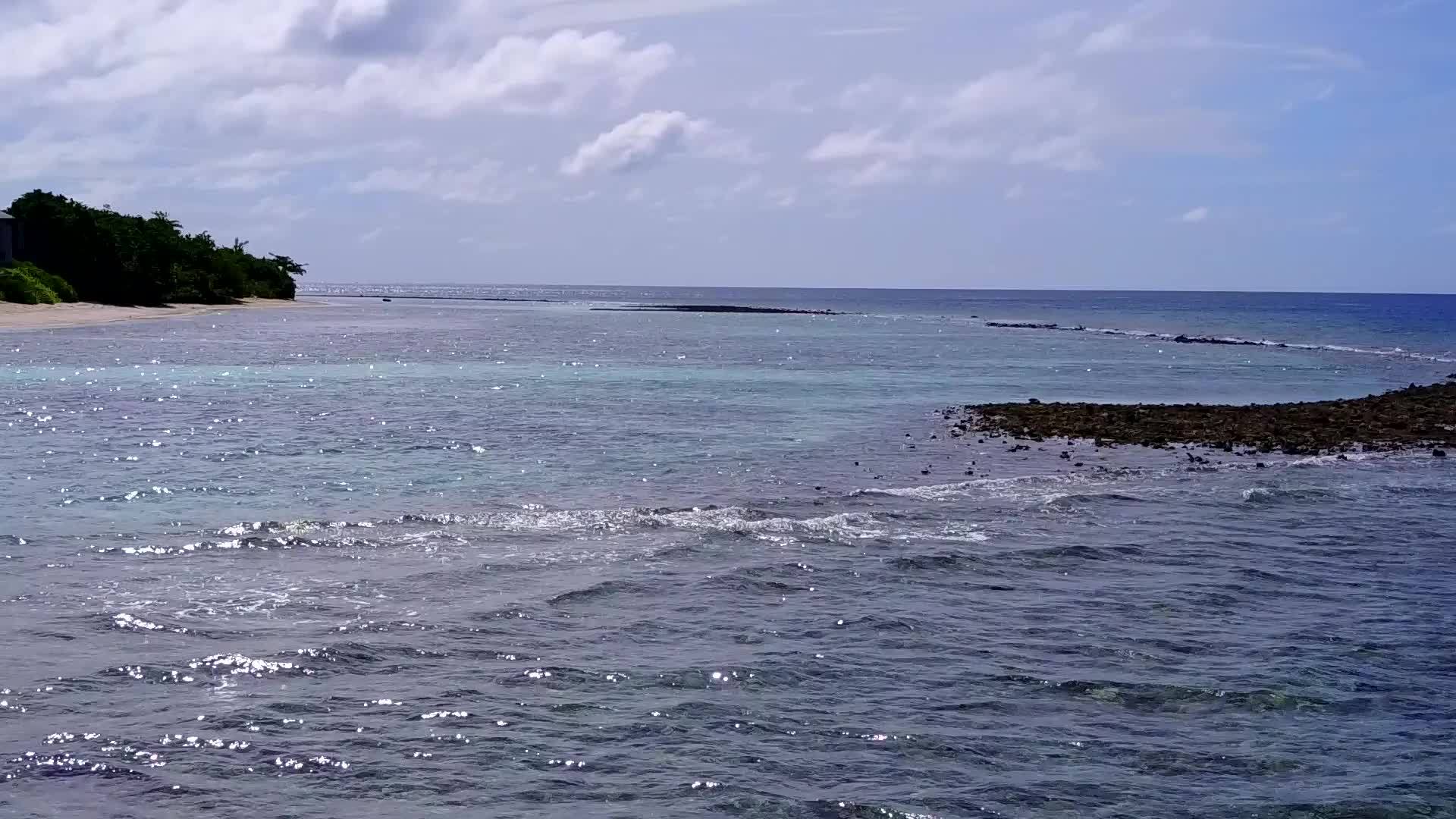 蓝色环礁湖和白色沙滩的背景是海浪附近的完美海滩视频的预览图